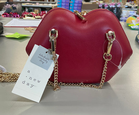 Red lip-shaped clutch with a detachable gold chain