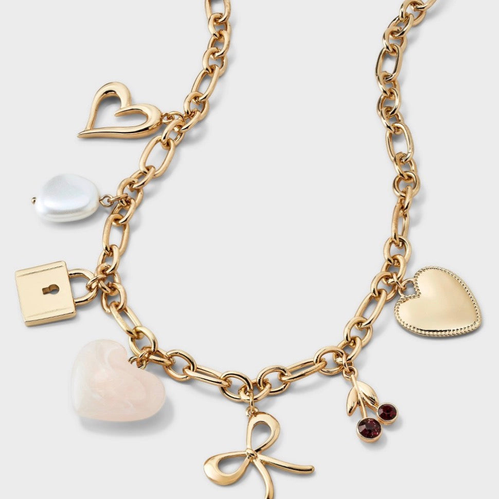 Gold-tone necklace featuring heart, pearl, and cherry charms