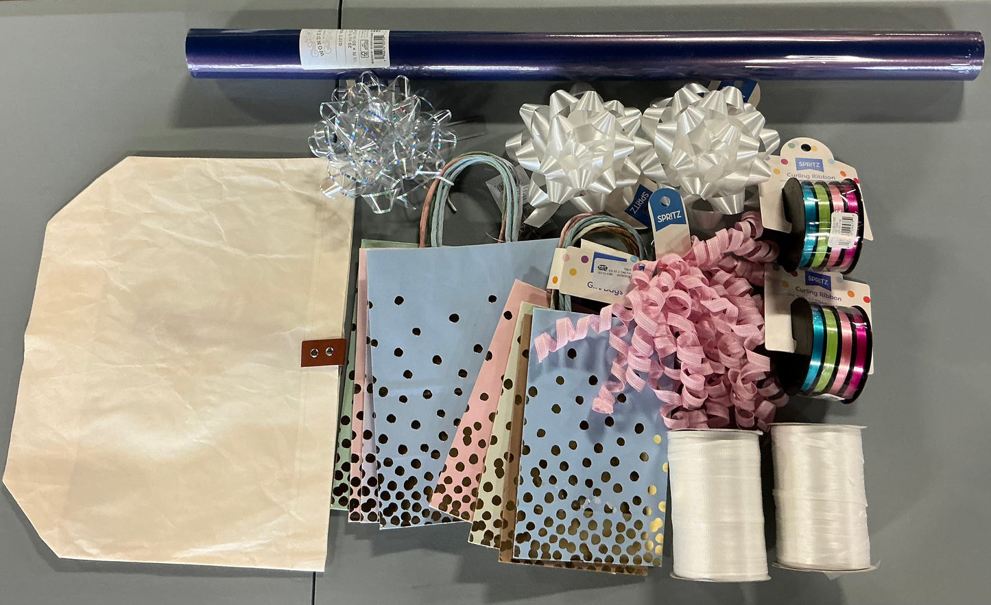 Gift Wrapping Bundle (includes 1 Tote, 1-(25sq ft)Blue Gift Wrap, 1 Clear Bow, 2 White Bows, 2 White Curling Ribbons, 2 (4 color) Curling Ribbons, 1 Curly Pink Bow, 1 (4 color) XS Gift Bags (slight damage, see picture), 1 (4 color) Small Bags)
