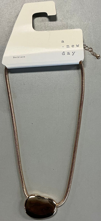 Gold-tone pendant necklace featuring a sleek snake chain and an oval-shaped charm