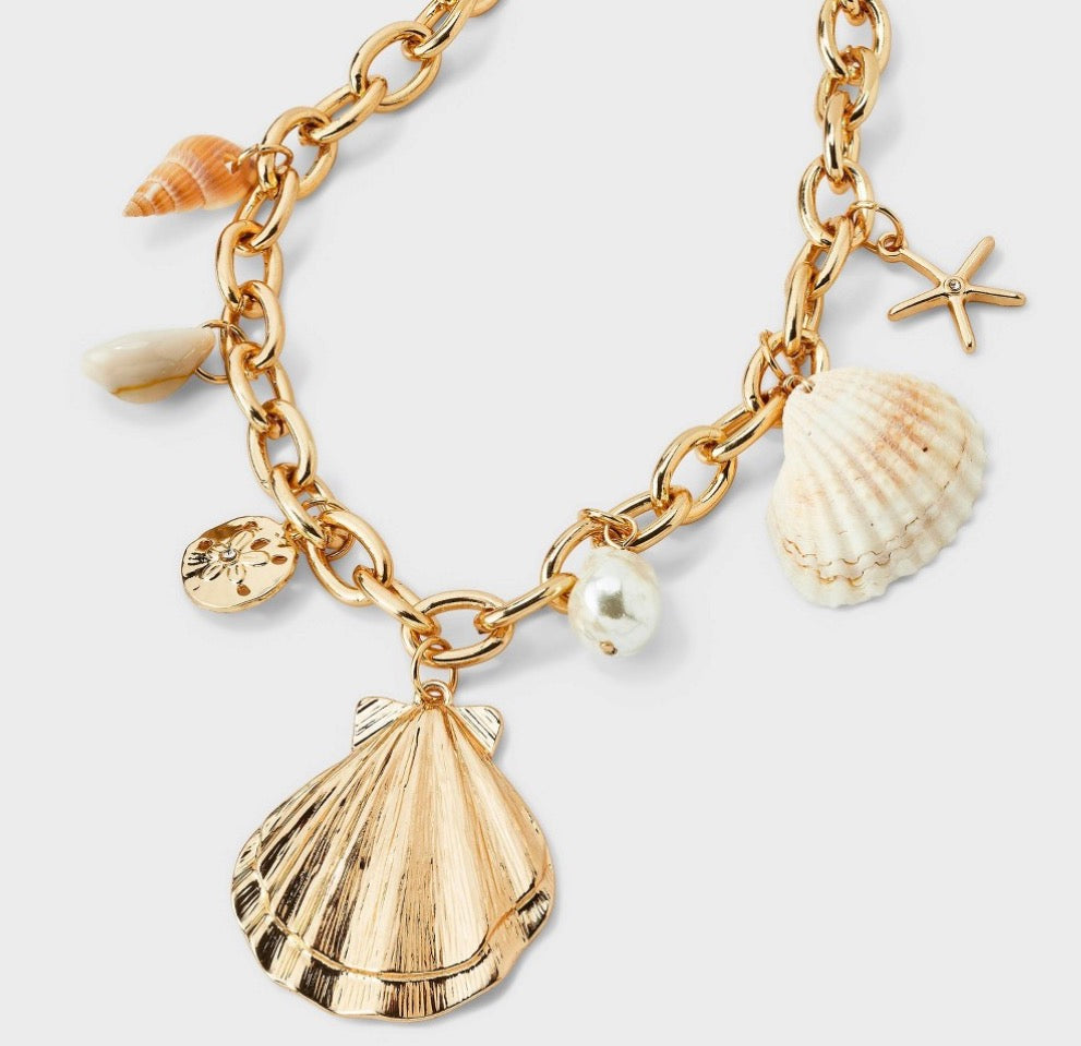 Gold-colored charm necklace featuring various seashell and starfish charms