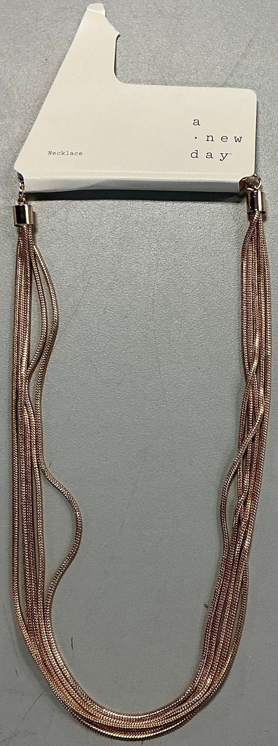 Multi-strand gold-tone necklace featuring multiple layers of snake chains