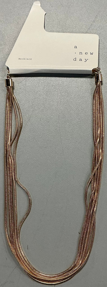 Multi-strand gold-tone necklace featuring multiple layers of snake chains