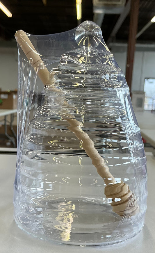 Clear glass ribbed beehive honey pot with a wooden dipper