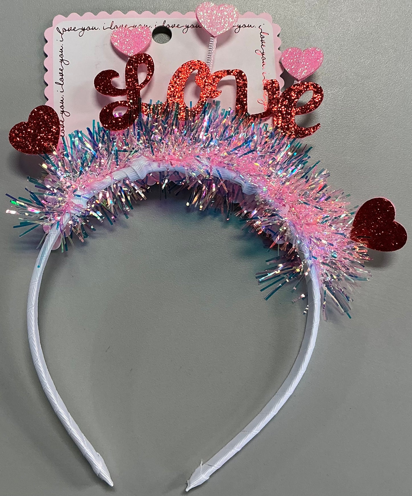 "Love" tinsel headband featuring pink and iridescent fringe with red glitter hearts