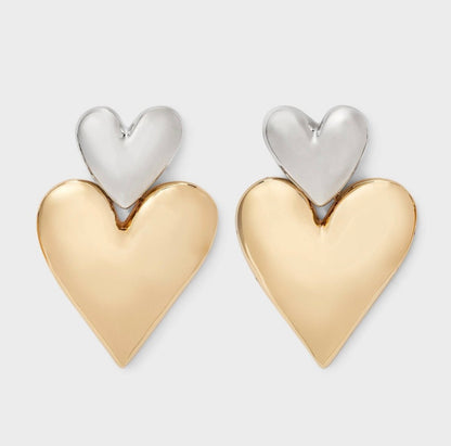 Two-toned heart stud earrings featuring a shiny silver-toned smaller heart on top of a larger gold-toned heart