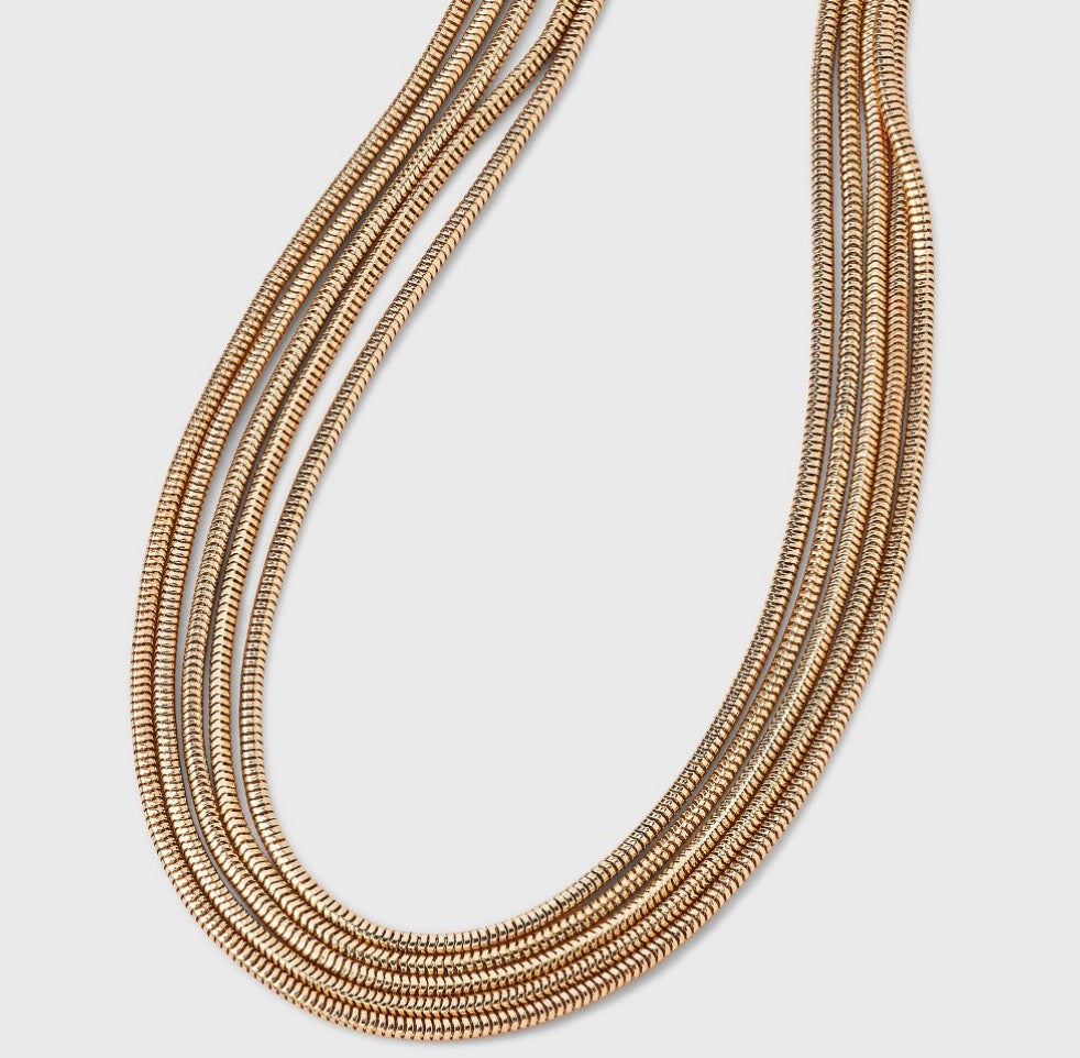 Multi-strand gold-tone necklace featuring multiple layers of snake chains