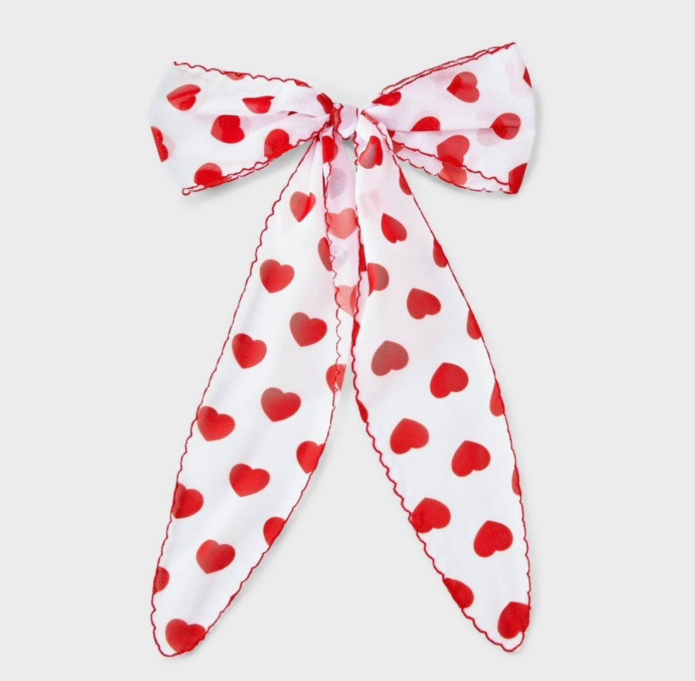 Hair bow featuring a red heart print and red stitching along the edges