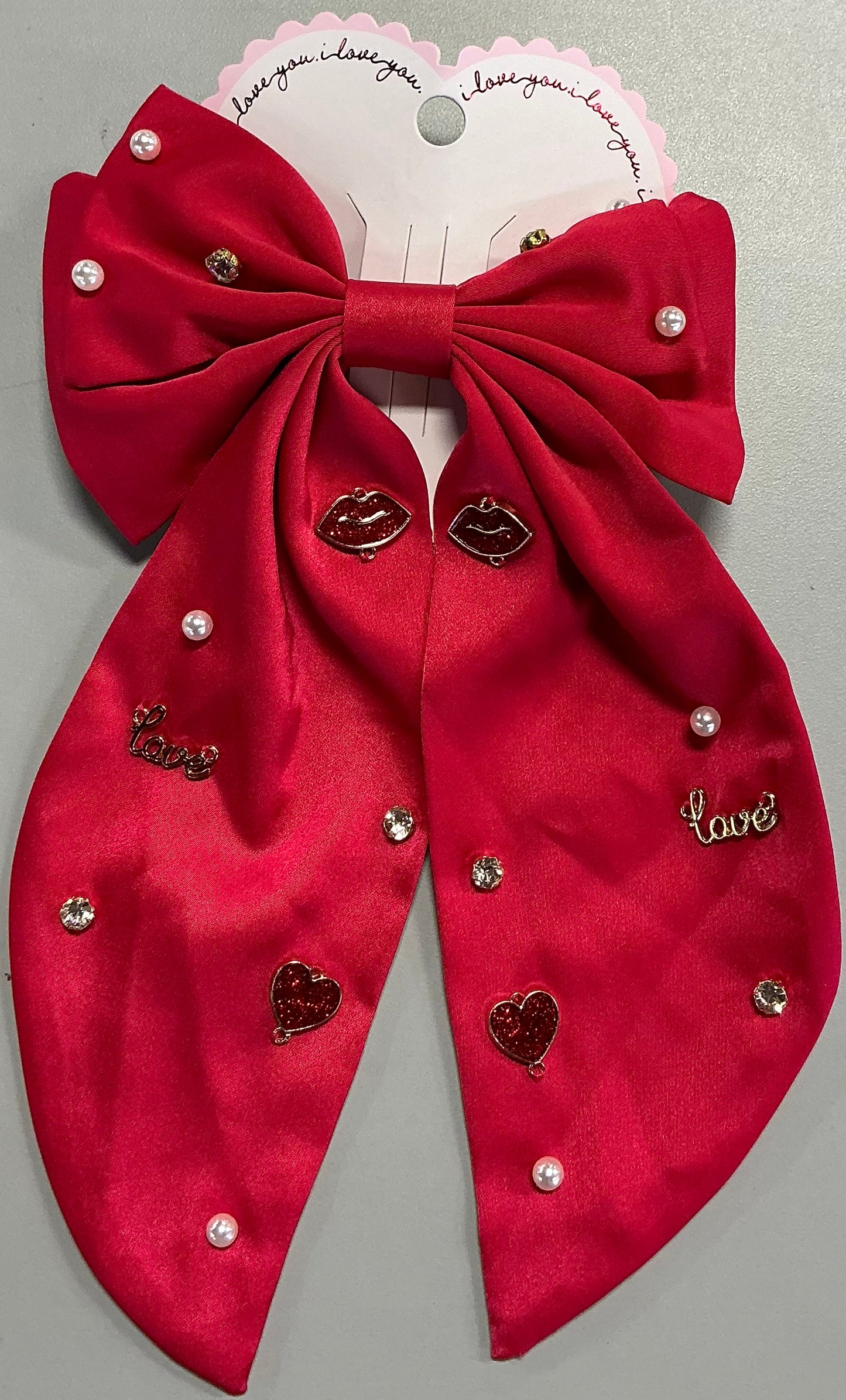 Red satin bow hair barrette adorned with pearl beads, rhinestone crystals, lips, and "love" charms