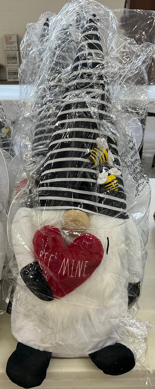 Rae Dunn Valentine's Day plush gnome featuring a black and white striped hat with bees and holding a red heart embroidered with "BEE MINE"