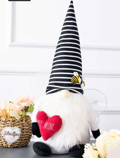 Rae Dunn Valentine's Day plush gnome featuring a black and white striped hat with bees and holding a red heart embroidered with "BEE MINE"