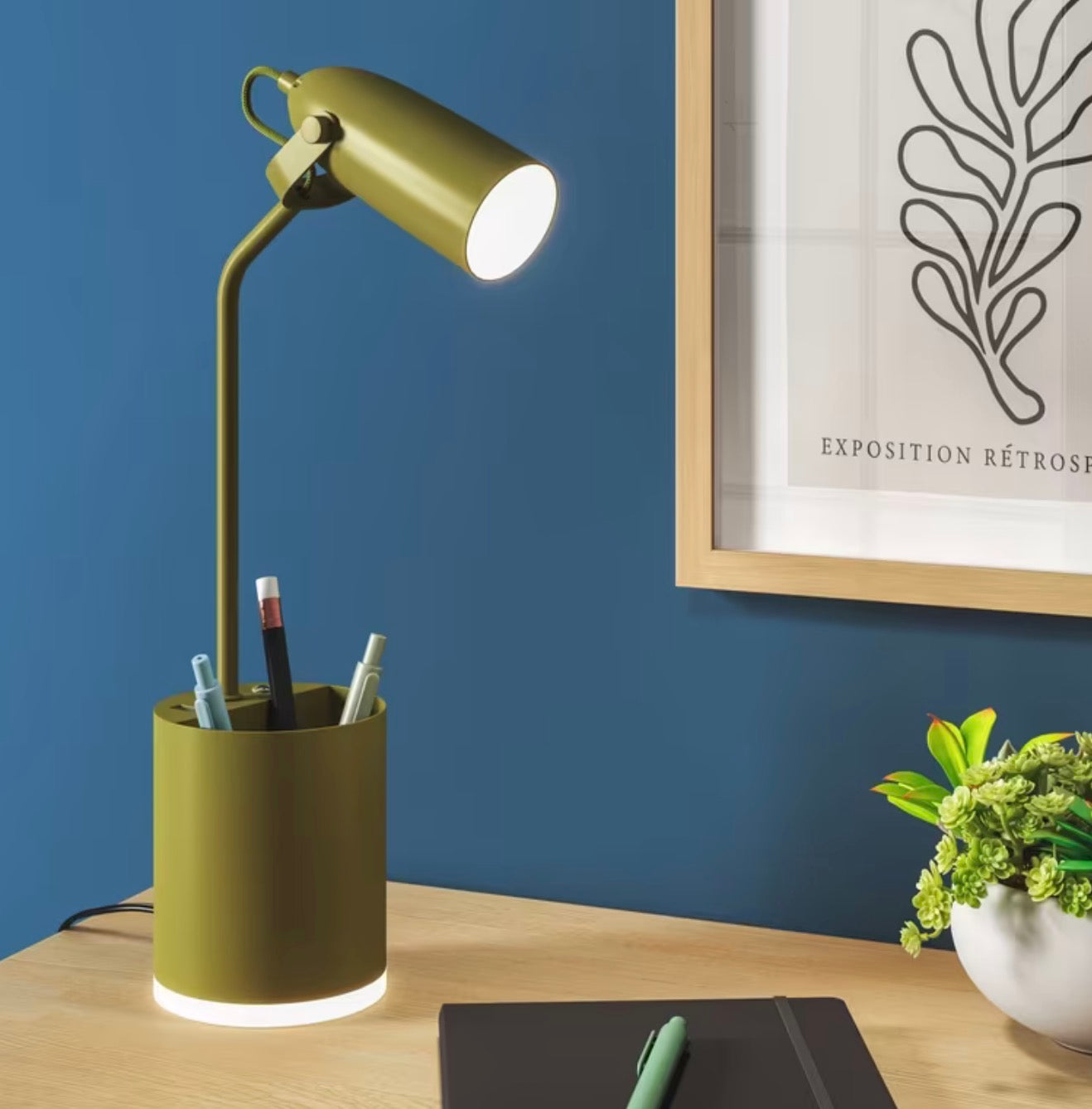 Olive green task table lamp with an integrated LED bulb, a pen holder base, and USB charging ports