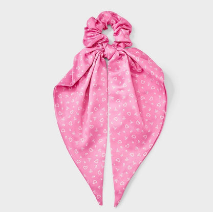 Pink satin hair twister featuring a white heart and bow print with long tails
