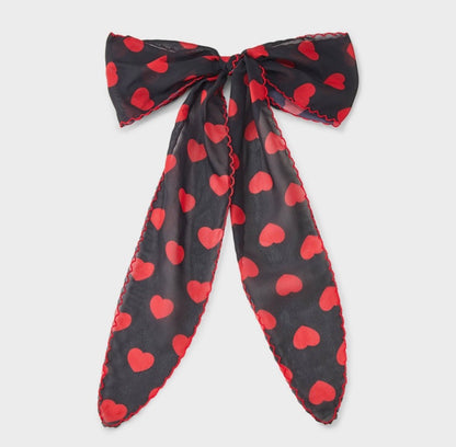 Hair bow featuring a red heart print and red stitching along the edges